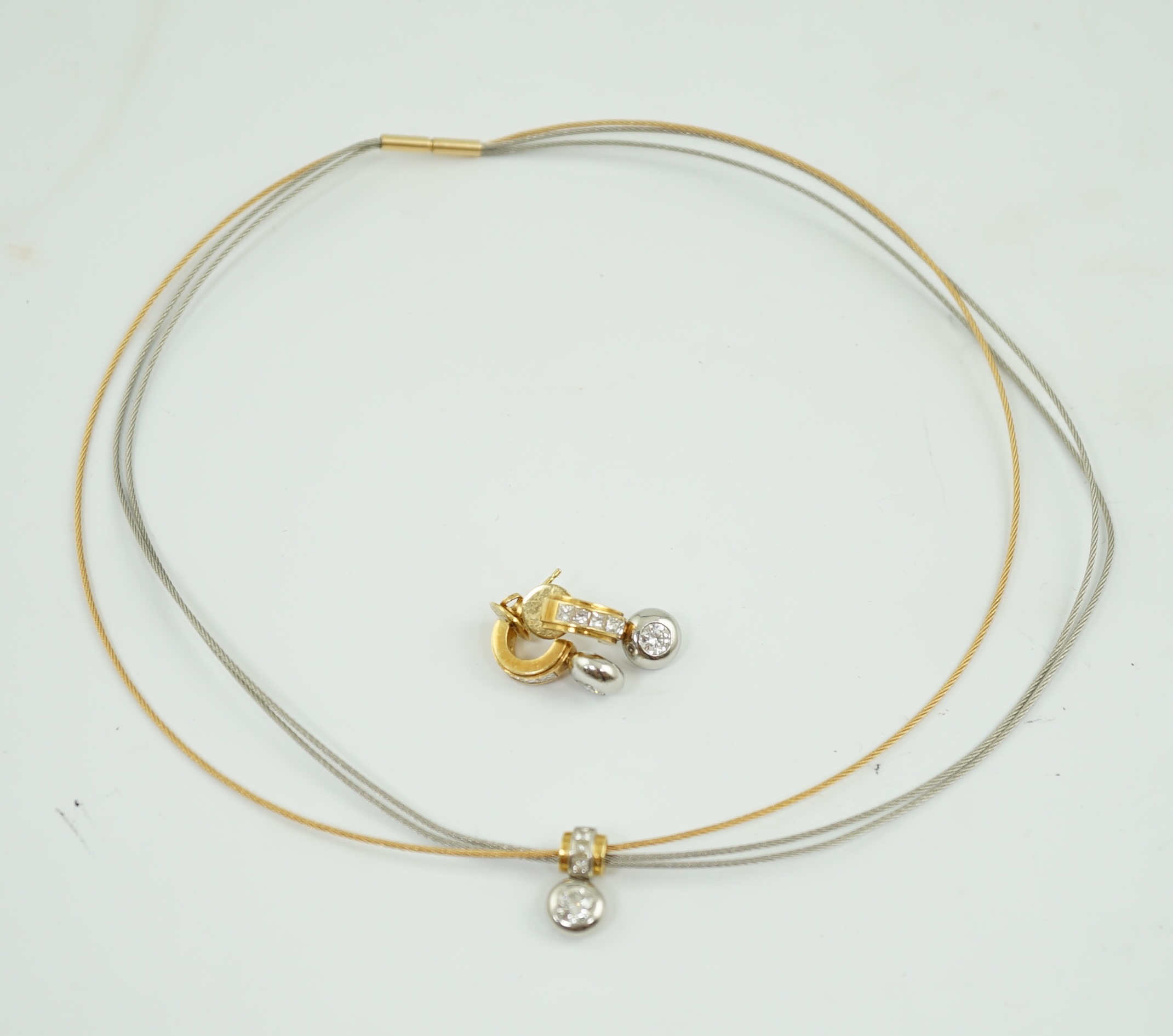 A modern platinum and 18k gold triple strand necklet, with round and princess cut diamond set pendant and a pair of matching earrings